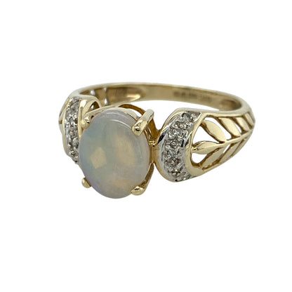 This pre-owned 9ct yellow gold diamond and opalique ring is a decorative gemstone design, featuring an oval opalique stone with diamond detailing and patterned shoulders.

Design: Featuring an oval opalique centre stone with diamonds on the shoulders, this ring has an open leaf-style patterned band finished in warm 9ct yellow gold.
Material: Made from 9-carat yellow gold.
Gemstone Detail: Oval opalique stone measuring approximately 9mm by 7mm with diamond detailing on the shoulders.
