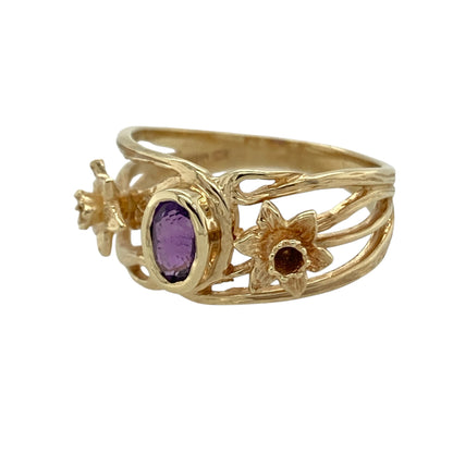 This pre-owned 9ct Welsh gold amethyst daffodil ring is a distinctive Welsh-inspired design, featuring an oval amethyst with decorative daffodil detailing.

Design: Featuring an oval amethyst centre stone with a daffodil motif on either side, this ring combines rich purple tones with a traditional Welsh-inspired design.
Material: Made from 9-carat Welsh gold.
Gemstone Detail: Oval amethyst stone measuring approximately 6mm by 4mm.
Ring Detail: Daffodil detailing on either side of the centre stone.