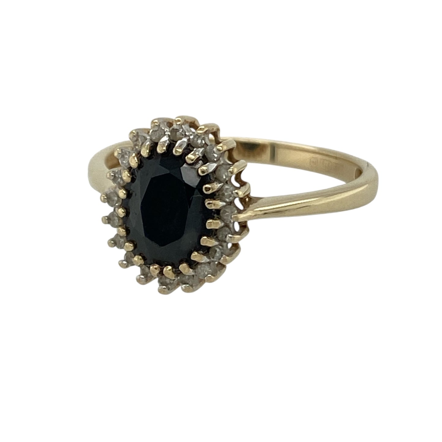 This pre-owned 9ct yellow gold diamond and sapphire cluster ring is a classic gemstone design, featuring an oval sapphire surrounded by diamond detailing.

Design: Featuring an oval sapphire centre stone with diamond detailing around, this cluster ring combines rich blue tones with the warm finish of 9ct yellow gold.
Material: Made from 9-carat yellow gold.
Gemstone Detail: Oval sapphire stone measuring approximately 8mm by 6mm with diamond detailing around.
Ring Detail: Sapphire and diamond cluster design.