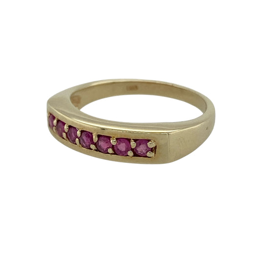 This pre-owned 9ct yellow gold ruby band ring is a classic gemstone design, featuring seven ruby stones set across the front.

Design: Featuring seven ruby stones set across the front of the band, this ring combines rich red tones with the warm finish of 9ct yellow gold.
Material: Made from 9-carat yellow gold.
Gemstone Detail: Set with seven ruby stones.
Ring Detail: Front of the band measures approximately 4mm wide.
Size & Weight: Ring size K. Total weight 2.60 grams.