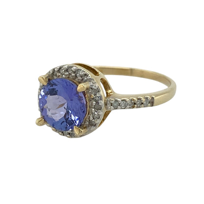 This pre-owned 9ct yellow gold diamond and tanzanite cluster ring is a colourful gemstone design, featuring a round tanzanite surrounded by diamonds with further diamond detailing along the band.

Design: Featuring a round tanzanite centre stone surrounded by diamonds, this cluster ring also has diamonds set along half of the band and is finished in warm 9ct yellow gold.
Material: Made from 9-carat yellow gold.