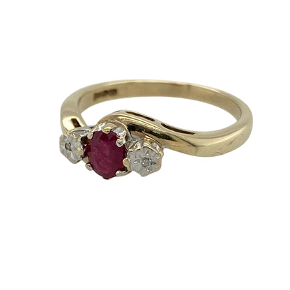 This pre-owned 9ct yellow gold diamond and ruby trilogy twist ring is a classic gemstone design, featuring a central ruby with illusion-set diamonds on either side.

Design: Featuring a trilogy twist design with an oval ruby at the centre and an illusion-set diamond on either side, this ring combines rich red tones with the warm finish of 9ct yellow gold.
Material: Made from 9-carat yellow gold.
Gemstone Detail: Oval ruby measuring approximately 5mm by 4mm with an illusion-set diamond on either side.