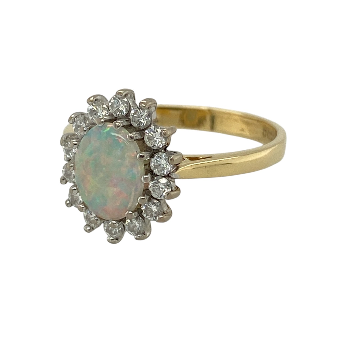This pre-owned 18ct yellow gold diamond and opalique cluster ring is a classic gemstone design, featuring an oval opalique centre surrounded by diamonds.

Design: Featuring an oval opalique centre stone surrounded by diamonds in a classic cluster setting, this ring is finished in warm 18ct yellow gold.
Material: Made from 18-carat yellow gold.
Gemstone Detail: Oval opalique stone measuring approximately 8mm by 6mm, surrounded by diamonds.
Ring Detail: Opalique and diamond cluster ring design.