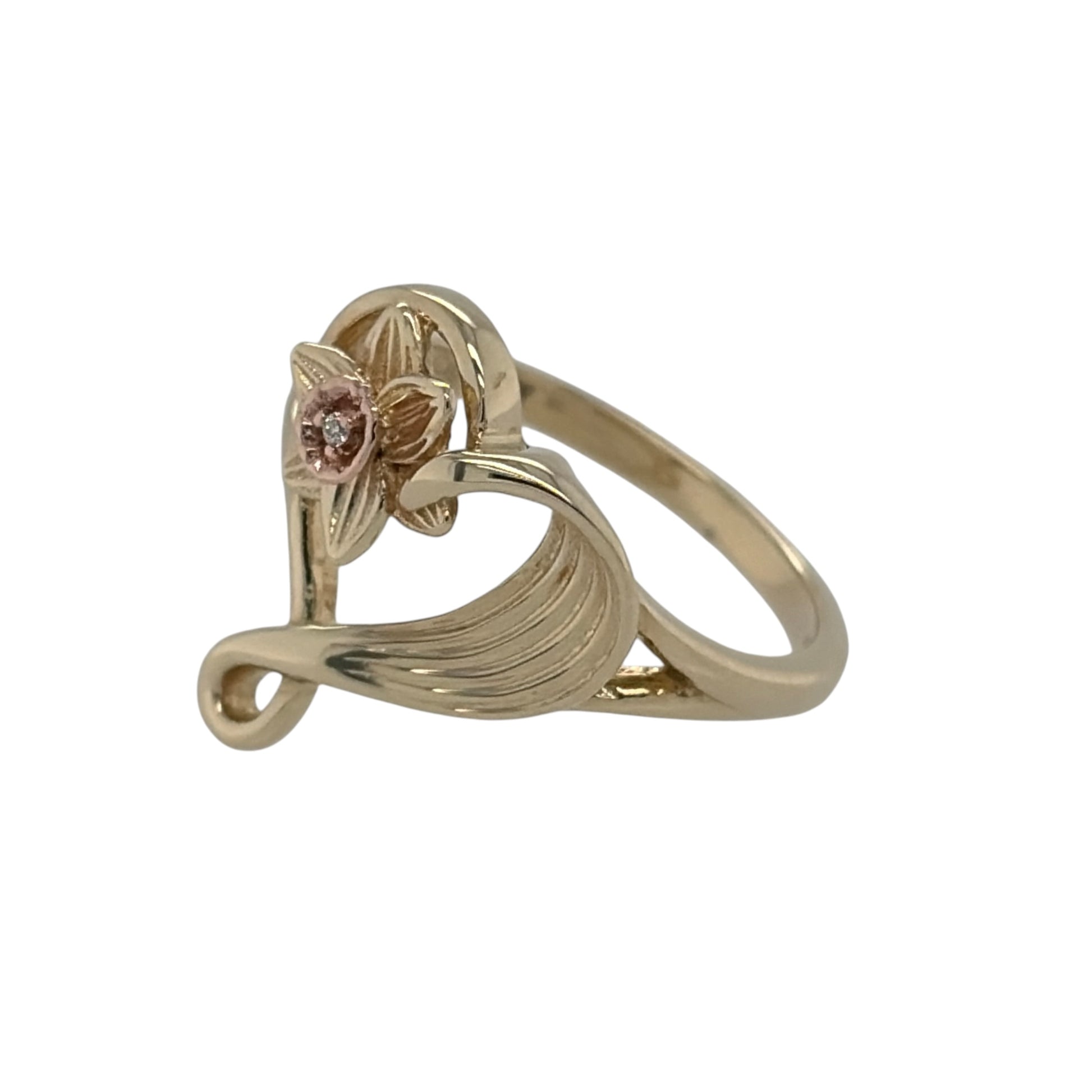 This pre-owned 9ct yellow and rose gold Clogau Daffodil heart ring is a beautiful Welsh-inspired design, featuring daffodil detailing and a diamond accent.

Design: Featuring a heart-shaped design with distinctive daffodil detailing, this Clogau ring combines yellow and rose gold for a contrasting two-tone finish.
Material: Made from 9-carat yellow and rose gold.
Gemstone Detail: Set with a diamond accent within the design.
Ring Detail: The front of the ring measures approximately 15mm high.