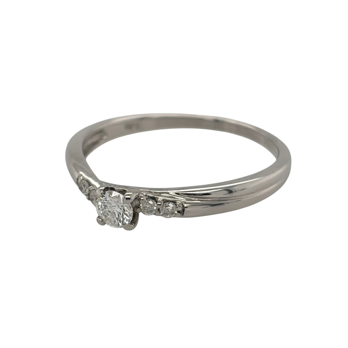 This pre-owned 9ct white gold diamond solitaire twist ring is a classic design, featuring a brilliant cut centre diamond complemented by smaller diamond detailing.

Design: Featuring a twist-style solitaire design, this ring showcases a brilliant cut centre diamond with two smaller diamonds set on each side.
Material: Made from 9-carat white gold.
Gemstone Detail: Set with a central brilliant cut diamond of approximately 0.20ct, complemented by four smaller diamonds, with two set on each side.