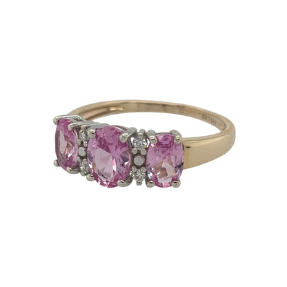 New 9ct Gold Lab Grown Diamond &amp; Lab Grown Pink Sapphire Trilogy Cluster Ring in various sizes with the approx weight 2.25 grams. There is approximatley 0.20ct of lab grown diamond content in the ring has approximate clarity i2 and colour J. The center lab grown pink sapphire oval stone is 7mm by 5mm and the side ones are 6mm by 4mm