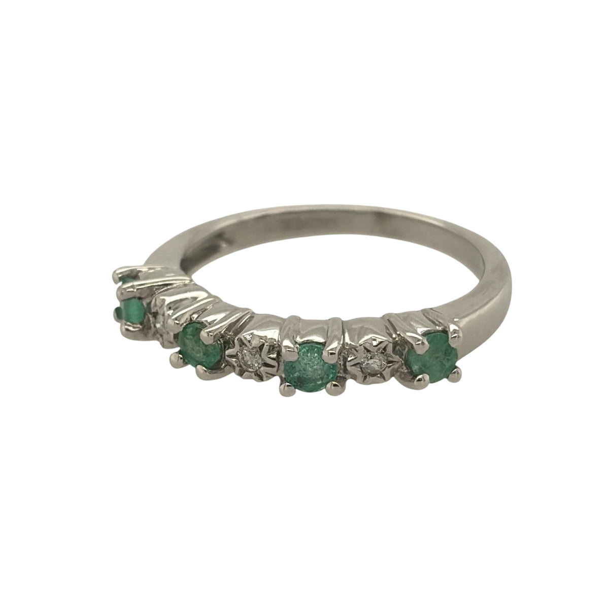 This pre-owned 9ct white gold diamond and emerald band ring is a classic gemstone design, featuring four round emeralds complemented by diamond detailing.

Design: Featuring a traditional gemstone band design, this ring has four round emeralds arranged across the front with diamond detailing in 9ct white gold.
Material: Made from 9-carat white gold.
Gemstone Detail: Set with four round emeralds measuring approximately 3mm in diameter each, complemented by diamond detailing.