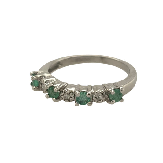 This pre-owned 9ct white gold diamond and emerald band ring is a classic gemstone design, featuring four round emeralds complemented by diamond detailing.

Design: Featuring a traditional gemstone band design, this ring has four round emeralds arranged across the front with diamond detailing in 9ct white gold.
Material: Made from 9-carat white gold.
Gemstone Detail: Set with four round emeralds measuring approximately 3mm in diameter each, complemented by diamond detailing.