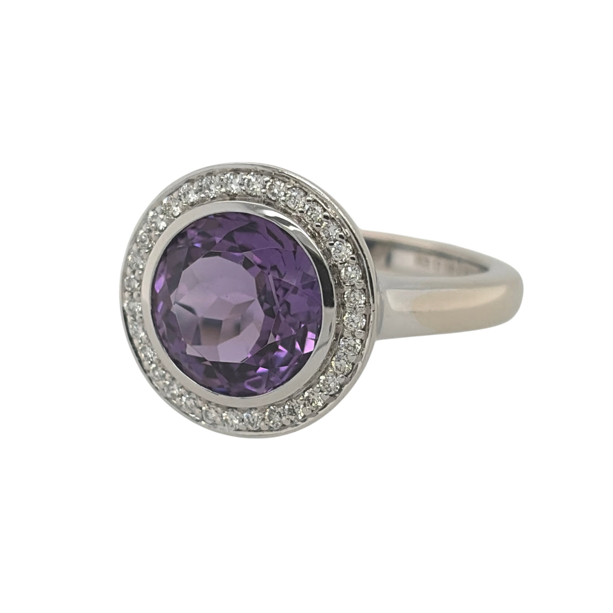 This pre-owned 18ct white gold diamond and amethyst halo ring is a striking statement design, featuring a large round amethyst surrounded by diamond detailing.

Design: Featuring a classic halo design, this ring showcases a large round amethyst as the centrepiece, surrounded by diamonds and finished in 18ct white gold.
Material: Made from 18-carat white gold.
Gemstone Detail: Set with a round amethyst measuring approximately 10mm in diameter, surrounded by diamond detailing.