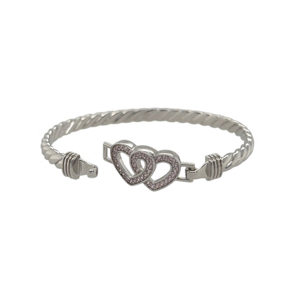 This new 925 sterling silver pink cubic zirconia set children’s double heart twisted bangle is a pretty design, featuring two heart details with colourful stone accents.

Design: Featuring a twisted bangle design with a double heart centrepiece, this children’s bangle has a polished silver finish with pink cubic zirconia detailing.
Material: Made from 925 sterling silver.
Gemstone Detail: Set with pink cubic zirconia stones across the heart design.