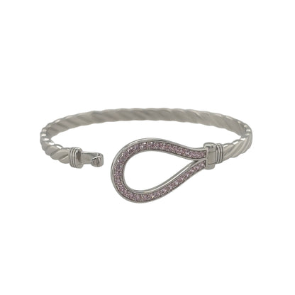 This new 925 sterling silver pink cubic zirconia set children’s horseshoe twisted bangle is a pretty design, featuring a horseshoe centrepiece with colourful stone detailing.

Design: Featuring a twisted bangle design with a horseshoe centrepiece, this children’s bangle has a polished silver finish with pink cubic zirconia detailing.
Material: Made from 925 sterling silver.
Gemstone Detail: Set with pink cubic zirconia stones across the horseshoe design.
