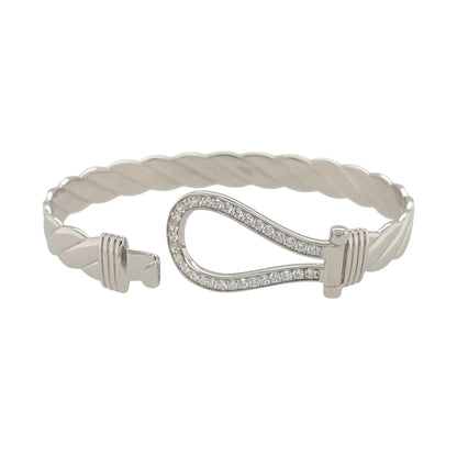 This new 925 sterling silver cubic zirconia set horseshoe twisted bangle is a substantial design, featuring a horseshoe centrepiece with stone detailing.

Design: Featuring a twisted bangle design with a horseshoe centrepiece, this bangle has a polished silver finish with cubic zirconia detailing.
Material: Made from 925 sterling silver.
Gemstone Detail: Set with cubic zirconia stones across the horseshoe design.
Bangle Detail: The front of the bangle measures approximately 20mm high.