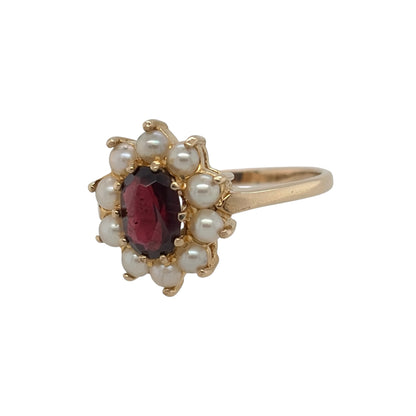 This pre-owned 9ct yellow gold garnet and seed pearl cluster ring is a traditional gemstone design, featuring an oval garnet centre surrounded by delicate seed pearls.

Design: Featuring a classic cluster design, this ring showcases an oval garnet centre stone surrounded by seed pearls in warm 9ct yellow gold.
Material: Made from 9-carat yellow gold.
Gemstone Detail: Set with a central oval garnet measuring approximately 7mm by 5mm, surrounded by seed pearls.