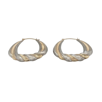 This pre-owned 9ct yellow and white gold brushed effect patterned twisted oval creole earrings are a distinctive two-tone design, featuring decorative detailing and a textured finish.

Design: Featuring a twisted oval creole design with patterned detailing and a brushed effect finish, these earrings combine contrasting yellow and white gold for a two-tone appearance.
Material: Made from 9-carat yellow and white gold.
Earring Detail: Each creole measures approximately 35mm by 27mm.