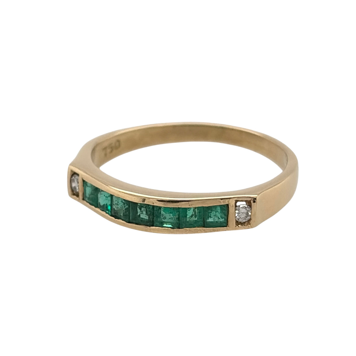 This pre-owned 18ct yellow gold diamond and emerald band ring is a classic gemstone design, featuring a row of princess cut emeralds with diamond detailing at either side.

Design: Featuring a gemstone-set band design, this ring showcases seven princess cut emeralds across the front, finished with a diamond at either end in warm 18ct yellow gold.
Material: Made from 18-carat yellow gold.
Gemstone Detail: Set with seven princess cut emerald stones, complemented by one diamond on either side.