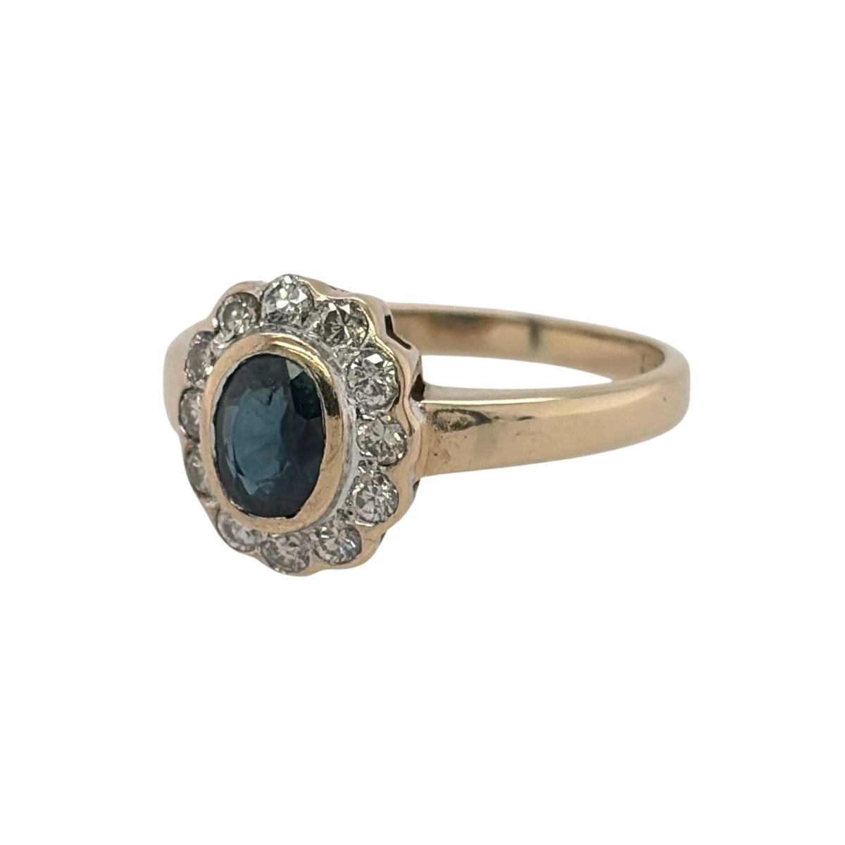 This pre-owned 9ct yellow gold diamond and sapphire cluster ring is a classic gemstone design, featuring an oval sapphire surrounded by contrasting diamond detailing.

Design: Featuring a traditional cluster design, this ring showcases an oval sapphire centre stone surrounded by diamonds in warm 9ct yellow gold.
Material: Made from 9-carat yellow gold.
Gemstone Detail: Set with a central oval sapphire measuring approximately 5mm by 4mm, complemented by surrounding diamonds.