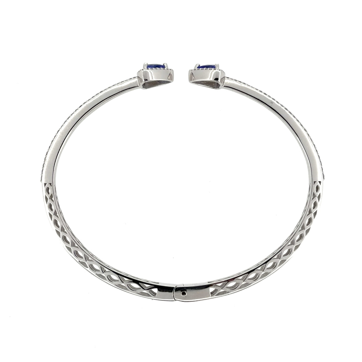 This pre-owned 18ct white gold diamond and tanzanite bangle is a striking torque-style design, featuring tanzanite stones with detailed diamond setting.
Design: Featuring an open torque-style design, this bangle has a triangular tanzanite stone at each end, surrounded by diamonds, with a double row of diamonds extending around half of the bangle.
Material: Made from 18-carat white gold.