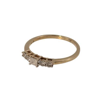 Add timeless diamond detail to your jewellery collection with this pre-owned 9ct yellow gold five-stone diamond band ring, featuring a princess-cut centre diamond complemented by brilliant-cut diamonds.

Design: The ring features a five-stone design with a princess-cut diamond at the centre and two brilliant-cut diamonds positioned on either side, creating a balanced arrangement across the band.