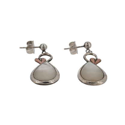 Bring natural beauty and symbolic elegance to your look with these pre-owned 925 silver and 9ct rose gold mother of pearl Clogau Tree of Life style drop earrings—perfect for adding grace and meaning to any occasion.

Design: Each earring features an elegant 13mm by 9mm oval mother of pearl stone, adorned with delicate Tree of Life detailing in warm 9ct rose gold. The lustrous pearl backdrop complements the intricate branches, symbolising growth, renewal, and connection.