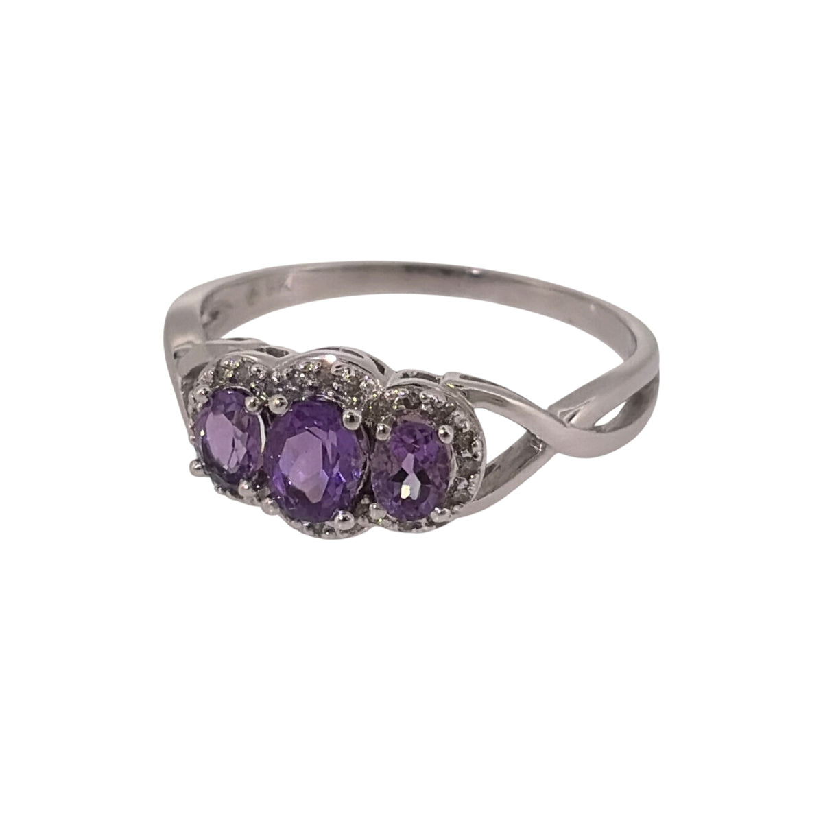 Add a touch of colour to your jewellery collection with this pre-owned 9ct white gold diamond and amethyst-coloured trilogy ring, featuring three oval stones with additional diamond detailing.

Design: The ring features a classic trilogy design, with a larger central oval stone accompanied by two smaller oval stones and diamond detailing around the setting.
Material: Made from 9-carat white gold, the bright white finish complements the purple amethyst-coloured stones and diamond accents.