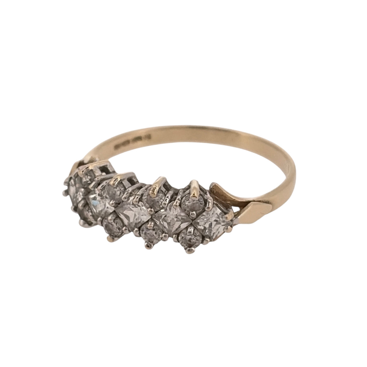 Add classic stone-set detail to your jewellery collection with this pre-owned 9ct yellow gold cubic zirconia cluster band ring, featuring a combination of round and square-cut stones.

Design: The ring features a cluster-style band design, combining round and square-cut cubic zirconia stones across the front for a detailed and distinctive appearance.
Material: Made from 9-carat yellow gold, the warm gold tone provides a classic setting for the cubic zirconia stones.