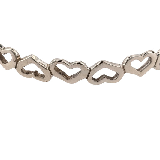 Add a charming piece to your jewellery collection with this pre-owned 925 sterling silver open heart bangle, featuring a decorative heart design and a classic silver finish.

Design: The bangle features an open heart design, creating a delicate and timeless appearance suitable for everyday wear or special occasions.
Material: Made from 925 sterling silver, complementing the elegant heart detailing.