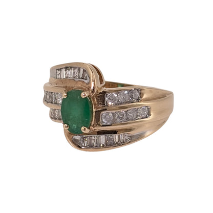 Add an elegant piece to your jewellery collection with this pre-owned 9ct yellow gold diamond and emerald ring, featuring an oval emerald surrounded by a decorative twisted diamond design.

Design: The ring features a central oval emerald with three rows of diamonds twisting around the stone, creating a distinctive and flowing appearance.
Material: Made from 9ct yellow gold, offering a warm gold finish that complements the green emerald and diamonds.