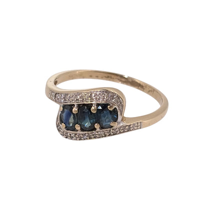 Add an elegant piece to your jewellery collection with this pre-owned 9ct yellow gold diamond and sapphire twist trilogy ring, featuring three oval sapphires complemented by diamond detailing.

Design: The ring features a classic trilogy design with a decorative twist, combining three oval sapphires with diamond accents to create a flowing and timeless appearance.
Material: Made from 9ct yellow gold, offering a warm gold finish that complements the sapphires and diamonds.