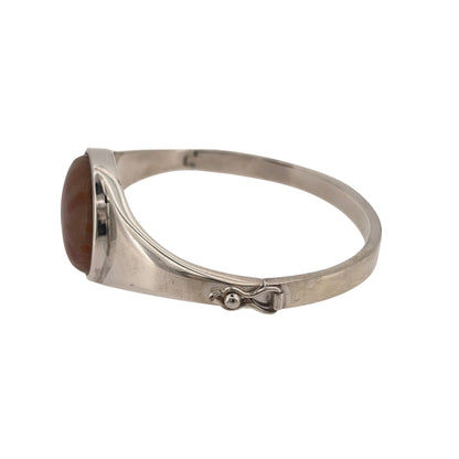 Add a colourful statement piece to your jewellery collection with this pre-owned 925 sterling silver and coral orange agate stone hinged bangle, featuring a large decorative agate stone and a substantial silver design.

Design: The bangle features a bold design with a prominent coral orange agate stone, creating an eye-catching contrast against the silver.
Material: Made from 925 sterling silver, offering a classic silver finish that complements the warm orange tones of the agate.