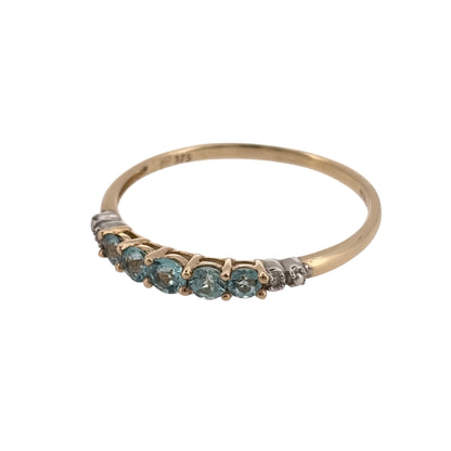 Add a colourful touch to your jewellery collection with this pre-owned 9ct yellow gold diamond and blue stone band ring, featuring five blue stones complemented by diamond detailing.

Design: The ring features a classic band design with five blue stones and decorative diamond detailing, creating an elegant and attractive appearance.
Material: Made from 9ct yellow gold, offering a traditional warm gold finish that complements the blue tones of the stones.