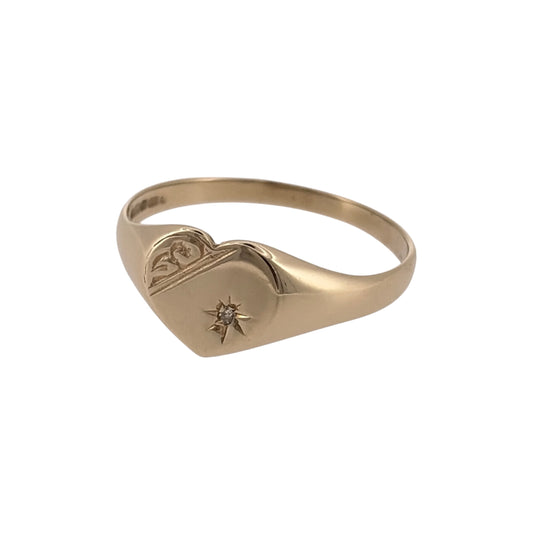 Add a charming touch to your jewellery collection with this pre-owned 9ct yellow gold and diamond heart signet ring, featuring a decorative heart design complemented by diamond detailing.

Design: The ring features a classic signet style with a heart-shaped front, creating an attractive and sentimental appearance.
Material: Made from 9ct yellow gold, offering a traditional warm gold finish.
Diamond Detail: Features diamond detailing that adds an elegant finishing touch to the heart design.