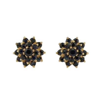 Add a classic touch of colour to your jewellery collection with these pre-owned 9ct yellow gold and sapphire cluster stud earrings, featuring beautiful sapphire stones arranged in a decorative cluster design.

Design: The earrings feature a traditional round cluster design, with sapphire stones creating an attractive and elegant appearance.
Material: Made from 9ct yellow gold, offering a warm gold finish that complements the rich blue tones of the sapphires.