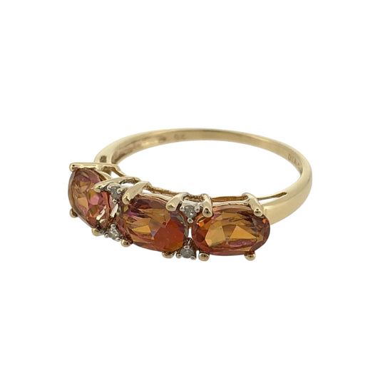 Add a colourful touch to your jewellery collection with this pre-owned 9ct yellow gold diamond and orange mystic topaz trilogy band ring, featuring three beautiful oval orange mystic topaz stones complemented by diamond detailing.

Design: The ring features a traditional trilogy design, with three oval orange mystic topaz stones arranged across the front of the band, creating an attractive and distinctive appearance.