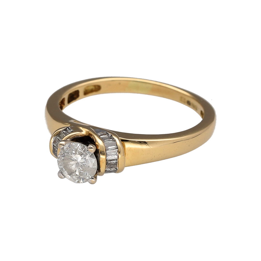 Make a timeless statement with this pre-owned 18ct yellow gold diamond solitaire ring. Featuring an impressive brilliant-cut centre diamond enhanced by elegant baguette-cut diamond shoulders, this sophisticated ring offers classic styling with added brilliance and character.

Design: The ring showcases a sparkling brilliant-cut centre diamond as its focal point, complemented by additional baguette-cut diamonds set into the shoulders.
