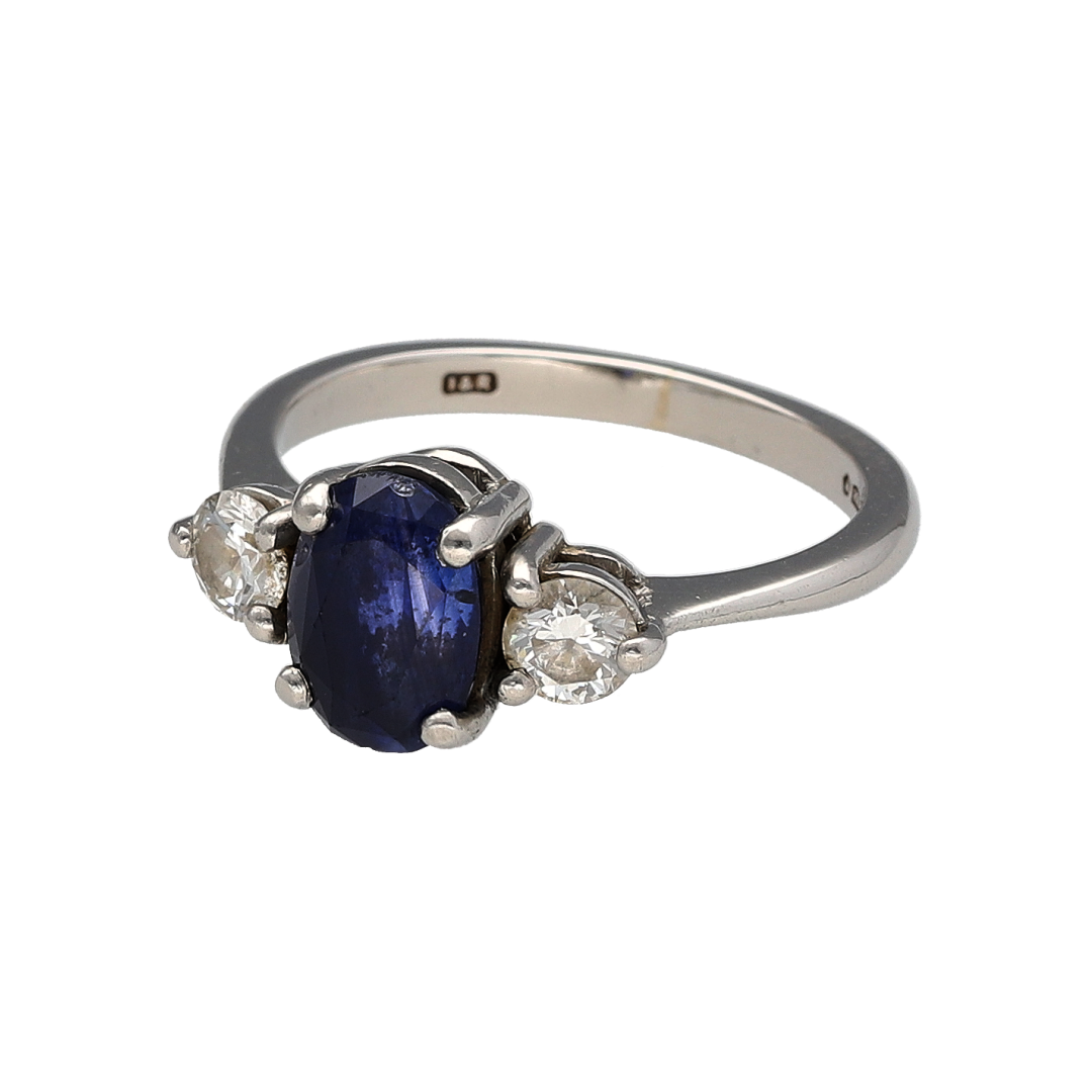 Experience timeless elegance with this pre-owned platinum diamond and sapphire trilogy ring. Featuring a striking oval sapphire flanked by sparkling diamonds, this classic trilogy design beautifully combines rich colour, exceptional brilliance, and enduring sophistication.

Design: The ring is centred by a stunning oval sapphire measuring approximately 8mm by 6mm, creating a vibrant focal point with its deep and captivating colour.