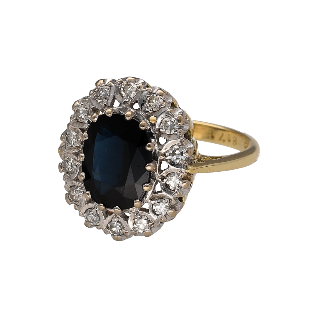 Elegant and timeless, this pre-owned 18ct yellow gold diamond and sapphire cluster ring is a stunning statement piece that showcases the classic beauty of a richly coloured sapphire surrounded by sparkling diamonds. Crafted in luxurious 18-carat gold, it is a sophisticated choice for special occasions or as a treasured addition to any jewellery collection.

Design: The ring features a classic cluster setting with a striking oval sapphire at its centre, framed by a halo of sparkling diamonds.