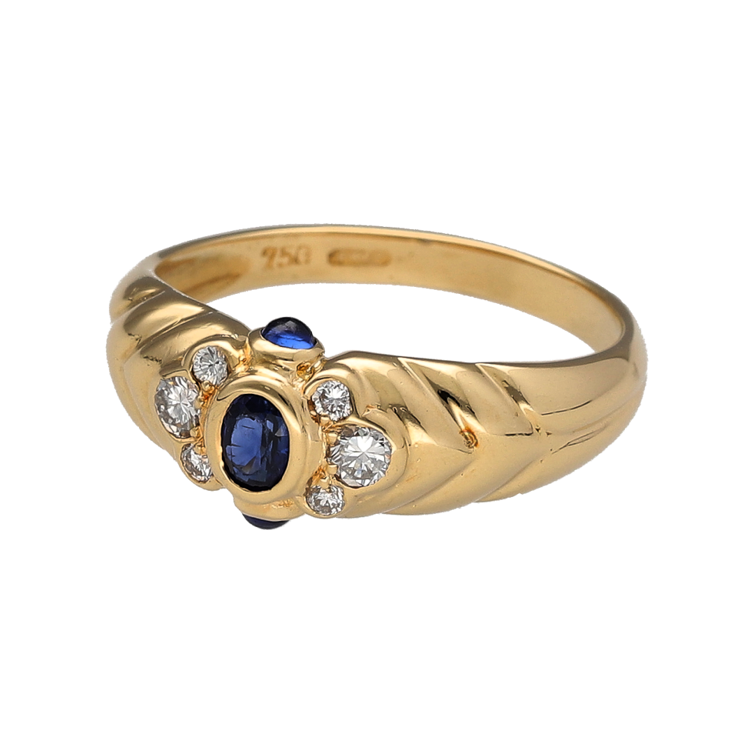 Discover timeless elegance with this pre-owned 18ct yellow gold diamond and sapphire ring, featuring a classic sapphire design enhanced by sparkling diamonds and beautifully patterned shoulders.

Design: The ring showcases a rich oval-cut sapphire measuring approximately 4mm by 3mm as its centrepiece, complemented by a sapphire set above and below to create an elegant vertical arrangement.