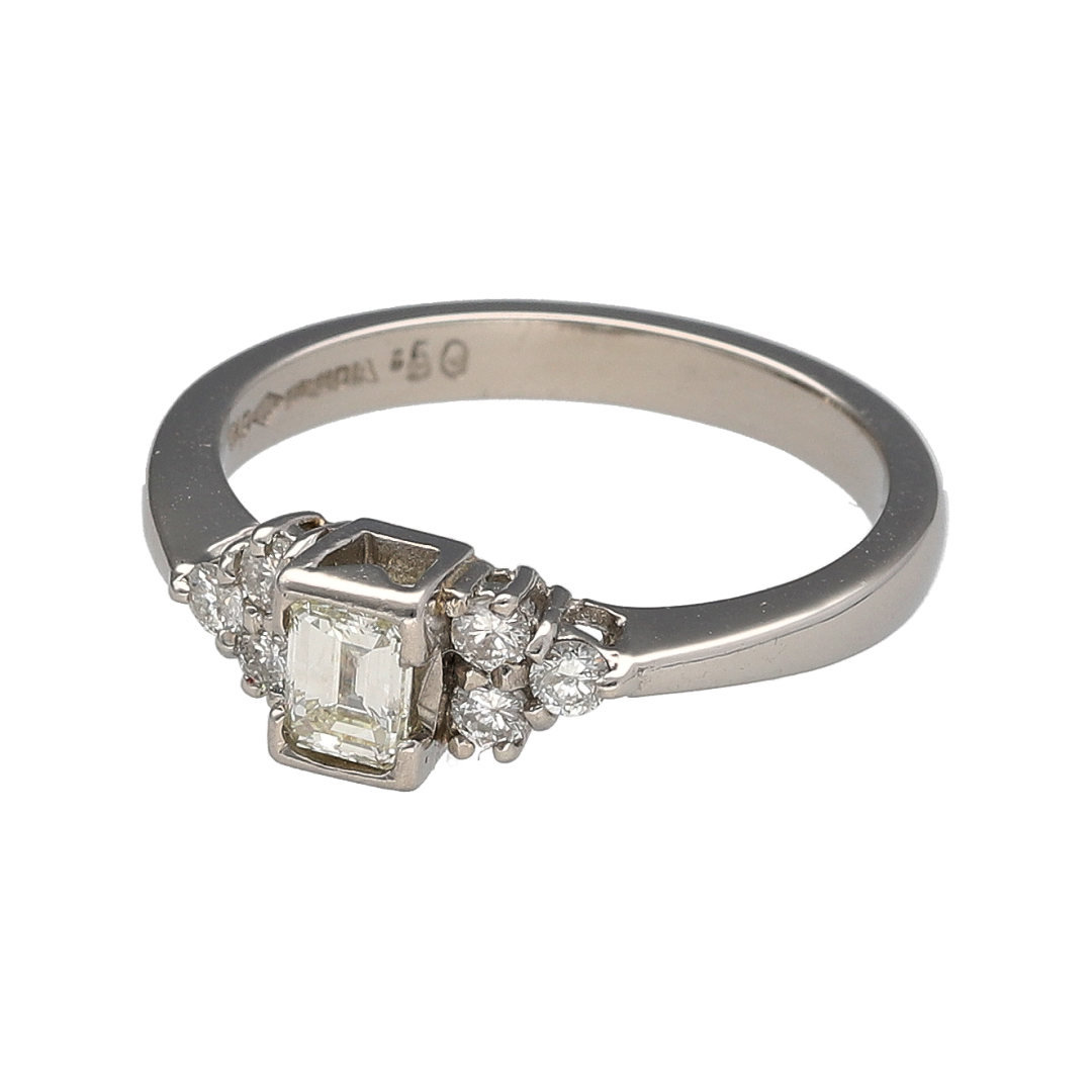 This pre-owned platinum diamond solitaire ring is a striking design, featuring an emerald cut centre diamond with brilliant cut diamond detailing on the shoulders.

Design: Featuring an emerald cut diamond at the centre with three brilliant cut diamonds set on either side, this ring has a classic stone-set design finished in platinum.
Material: Made from platinum.