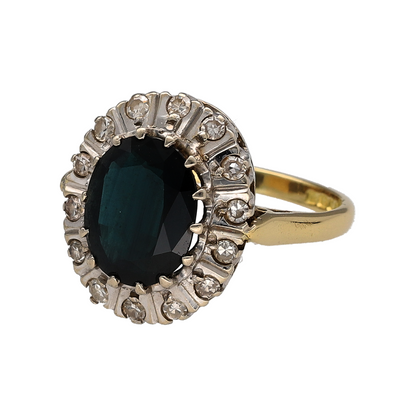 This pre-owned 18ct yellow gold diamond and sapphire cluster ring is a classic design, featuring a large oval sapphire surrounded by diamond detailing.

Design: Featuring a traditional cluster design, this ring showcases an oval sapphire as the centrepiece, complemented by diamonds set around the stone.
Material: Made from 18-carat yellow gold.
Gemstone Detail: Set with an oval sapphire measuring approximately 10mm by 8mm, surrounded by diamonds.