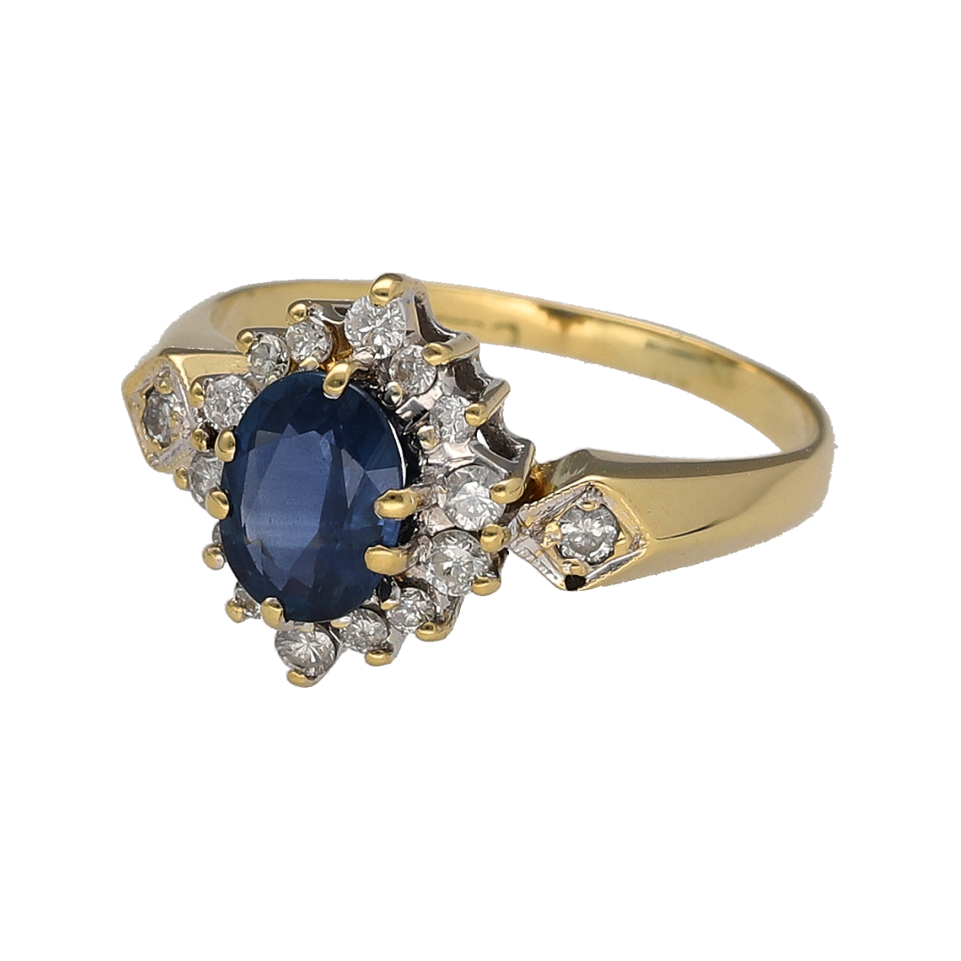 This pre-owned 18ct yellow gold diamond and sapphire cluster ring is a classic design, featuring an oval sapphire centre stone complemented by diamond detailing.

Design: Featuring a traditional cluster design, this ring showcases an oval sapphire as the centrepiece, surrounded by diamonds and finished in warm 18ct yellow gold.
Material: Made from 18-carat yellow gold.
Gemstone Detail: Set with an oval sapphire measuring approximately 7mm by 5mm, surrounded by diamond detailing.