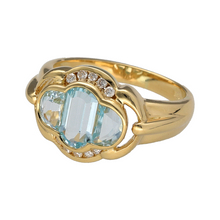 Load image into Gallery viewer, Preowned 18ct Yellow Gold Diamond &amp; Aquamarine Set Trilogy Ring in size M with the weight 5.30 grams. The center aqua coloured stone stone is 8mm by 5mm and the front of the ring is 13mm high
