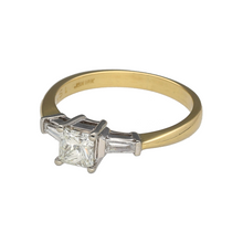 Load image into Gallery viewer, Add a timeless and sophisticated piece to your jewellery collection with this pre-owned 18ct yellow gold &amp; diamond set solitaire ring, featuring:

Design: A classic and elegant solitaire-style ring, enhanced by side diamonds for added brilliance.
Material: Crafted in 18-carat yellow gold, with white gold settings to enhance the diamonds&#39; sparkle.
Diamond Arrangement: Features a princess-cut diamond at the centre, flanked by two baguette-cut diamonds for a refined and balanced look.

