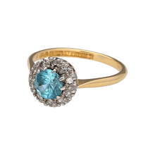 Load image into Gallery viewer, Add vintage-inspired elegance to your jewellery collection with this pre-owned 18ct yellow gold diamond and blue cubic zirconia cluster ring, featuring:

Design: A timeless cluster design with a light blue centre stone surrounded by a halo of sparkling diamonds, echoing vintage style with refined detail.
Material: 18-carat yellow gold, offering a rich, polished finish that enhances the brilliance of the diamonds and the soft hue of the central stone.

