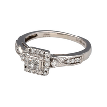 Load image into Gallery viewer, Bring refined brilliance and modern elegance to your collection with this pre-owned platinum diamond illusion set princess cut solitaire ring, featuring a striking design with layered sparkle—perfect for special occasions or timeless everyday luxury.

Design: The ring showcases a princess cut illusion set centre, surrounded by a sparkling diamond halo and finished with diamond-set shoulders, creating a bold yet elegant look. The total diamond content is approximately 0.38ct.

