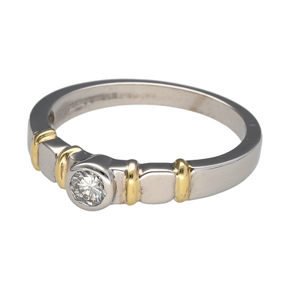 Bring modern elegance and refined contrast to your collection with this pre-owned 18ct white gold solitaire ring, featuring a rubover-set diamond and distinctive yellow gold shoulder accents—perfect for a sleek and sophisticated statement.

Design: The ring showcases a brilliant-cut diamond of approximately 0.25ct, securely held in a rubover setting that offers a smooth, contemporary profile. The diamond has an approximate clarity of VS2, ensuring impressive sparkle and clarity.