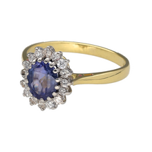 Load image into Gallery viewer, Bring rich colour and timeless sparkle to your collection with this pre-owned 18ct yellow gold diamond and sapphire cluster ring—a classic design with elegant sophistication.

Design: This ring features a 7mm by 6mm oval-cut sapphire at the centre, surrounded by a halo of brilliant-cut diamonds in a traditional cluster setting.
Material: Made from 18-carat yellow gold, the polished finish adds warmth and enhances the deep blue of the sapphire and the brilliance of the diamonds.

