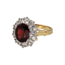 Load image into Gallery viewer, Bring rich colour and vintage-inspired elegance to your collection with this pre-owned 18ct yellow gold diamond and garnet cluster ring—perfect for adding a touch of luxury to any occasion.

Design: The ring features a 10mm by 8mm oval garnet at the centre, surrounded by a sparkling halo of diamonds for a timeless cluster effect.
Material: Made from 18-carat yellow gold, the polished finish enhances the warm tone of the metal and the deep red hue of the garnet.

