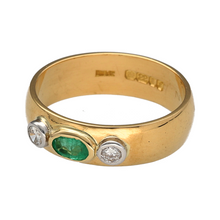 Load image into Gallery viewer, Bring rich colour and refined sparkle to your collection with this pre-owned 22ct yellow gold diamond and emerald band ring—a luxurious design with timeless elegance.

Design: The ring features an oval-cut emerald measuring 5mm by 3mm at the centre, flanked by two diamonds for a striking contrast of colour and brilliance.
Material: Made from 22-carat yellow gold, the polished finish enhances the vivid green of the emerald and the sparkle of the diamonds, adding a touch of luxury.

