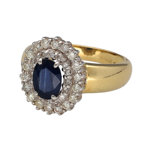 Add rich colour and sparkle to your collection with this pre-owned 18ct yellow gold sapphire and diamond cluster ring, a striking design with timeless elegance.

Design: The ring showcases an 8mm by 6mm oval sapphire at the centre, surrounded by two rows of brilliant diamonds that enhance its deep blue tone with radiant sparkle.
Material: Made in 18-carat yellow gold, the polished finish provides a warm backdrop that complements both the sapphire and the surrounding diamonds.