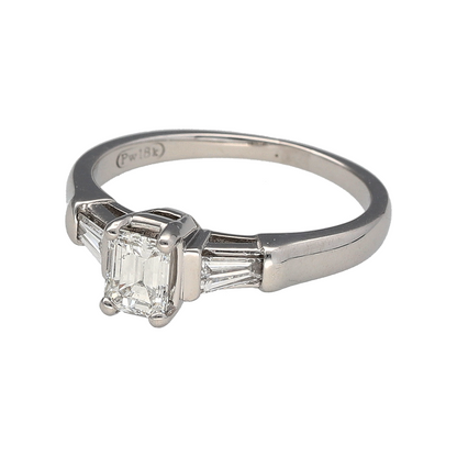 Add refined elegance and timeless sophistication to your jewellery collection with this pre-owned 18ct white gold diamond solitaire ring, offering striking structure and classic appeal.

Design: This ring features an emerald cut diamond at the centre measuring approximately 0.50ct, creating a sleek and elegant focal point. It is flanked by two tapered baguette cut diamonds, one on each side, each measuring approximately 0.10ct, adding balance and architectural detail to the design.